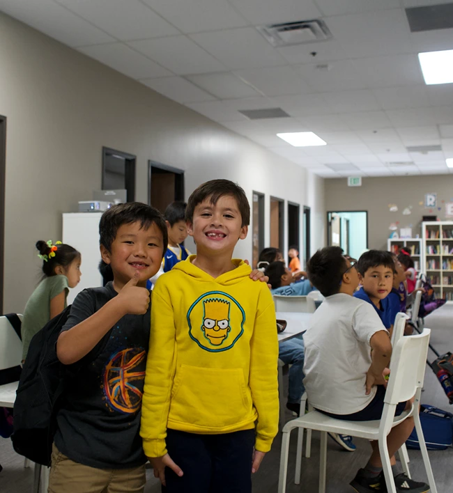 Six smiling, diverse students giving peace signs in an engaging our after-school programs